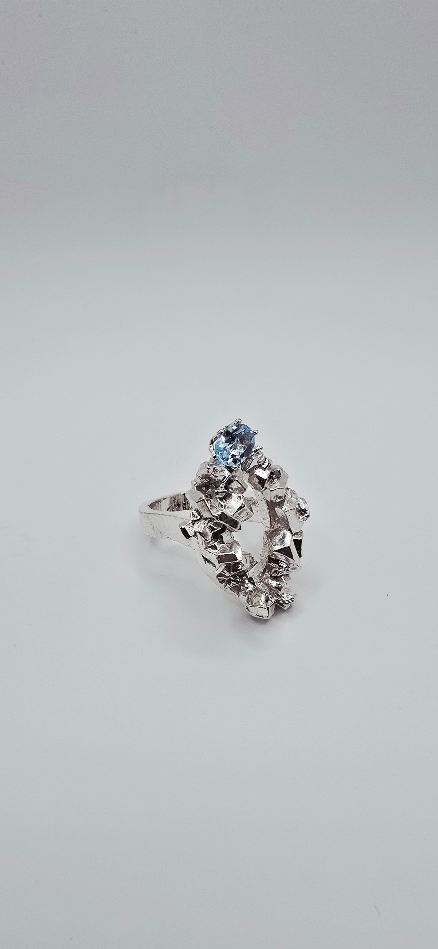 Solid sterling silver cocktail ring with a rock texture and features a sky blue topaz gemstone. Size 6.5 Made by Jill Melyssa