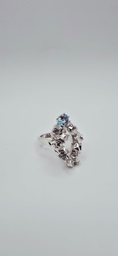 Solid sterling silver cocktail ring with a rock texture and features a sky blue topaz gemstone. Size 6.5 Made by Jill Melyssa