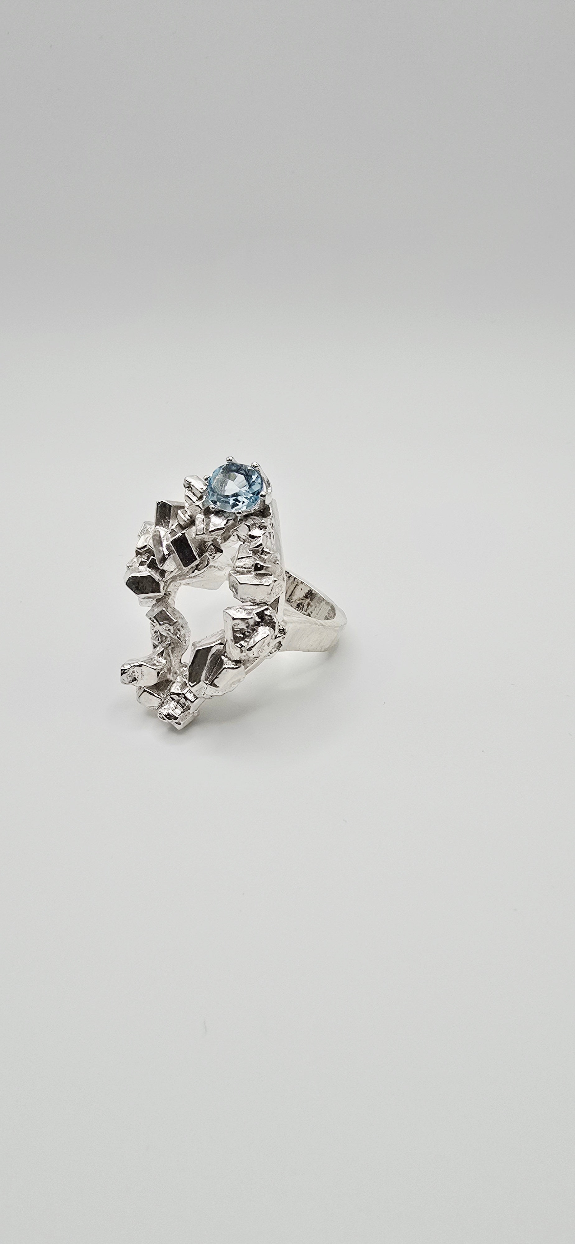 Solid sterling silver cocktail ring with a rock texture and features a sky blue topaz gemstone. Size 6.5 Made by Jill Melyssa