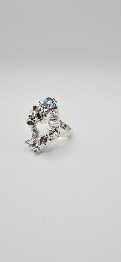 Solid sterling silver cocktail ring with a rock texture and features a sky blue topaz gemstone. Size 6.5 Made by Jill Melyssa