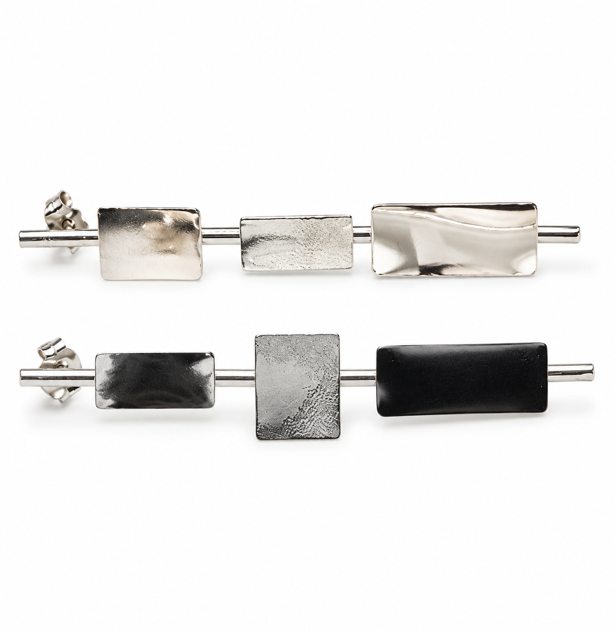 Clarity sterling silver geometric earrings shown horizontally, featuring three rectangular metal elements with contrasting smooth and textured surfaces.
