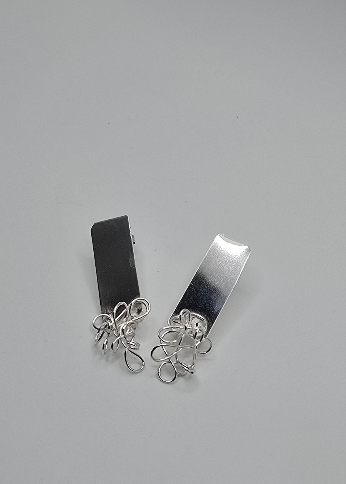 Coexistence sculptural sterling silver earrings featuring organic, freeform wire paired with smooth, geometric sheet metal forms, from Jill Melyssa’s Two Truths collection.