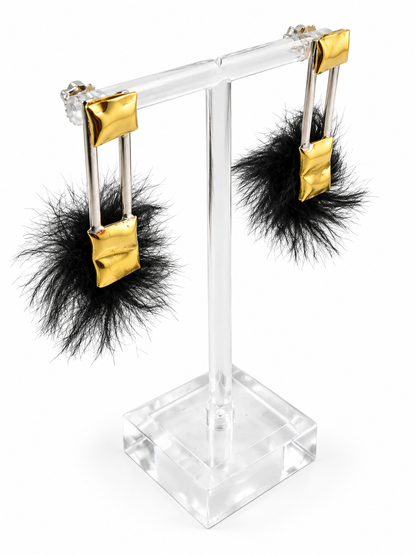 Comfort & Void mixed material earrings displayed from an angled view, highlighting the pillow inspired brass forms, tactile faux fur, and intentional negative space.