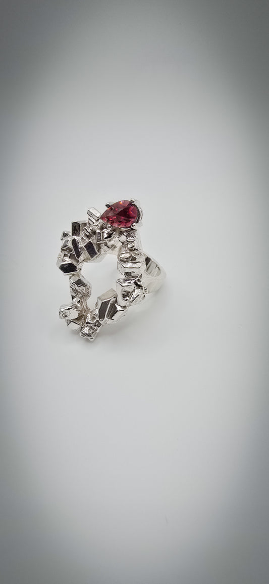 Solid sterling silver cocktail ring with a rock texture and features a pear garnet gemstone. Size 6.5 Made by Jill Melyssa