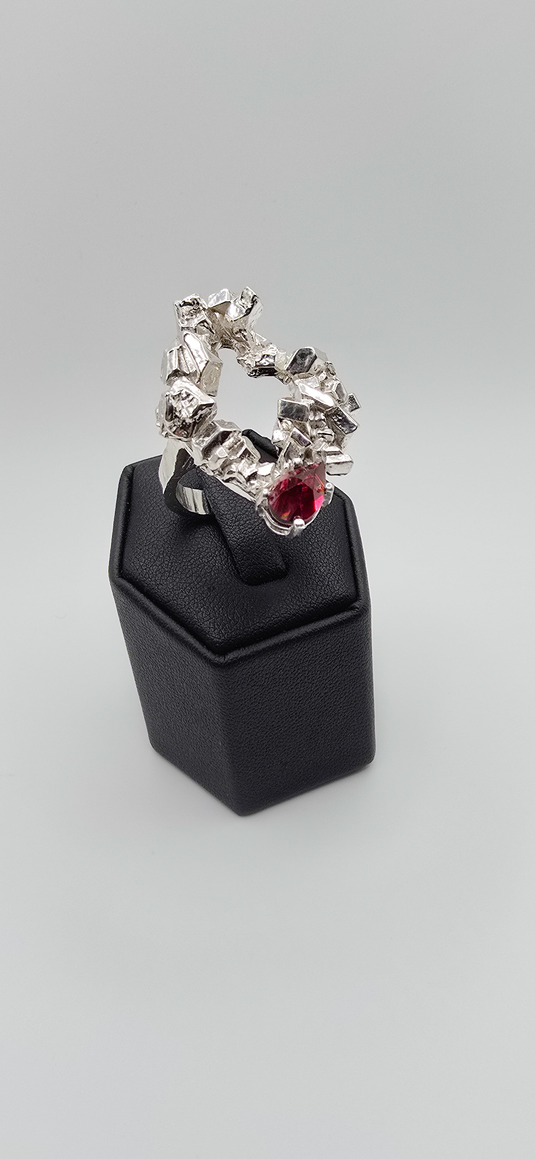 Solid sterling silver cocktail ring with a rock texture and features a pear garnet gemstone. Size 6.5 Made by Jill Melyssa