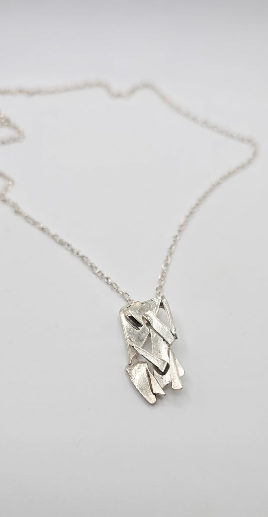 Made from shards of broken glass, this sterling silver pendant has a unique pattern. Comes on a 20" sterling chain. Made by Jill Melyssa