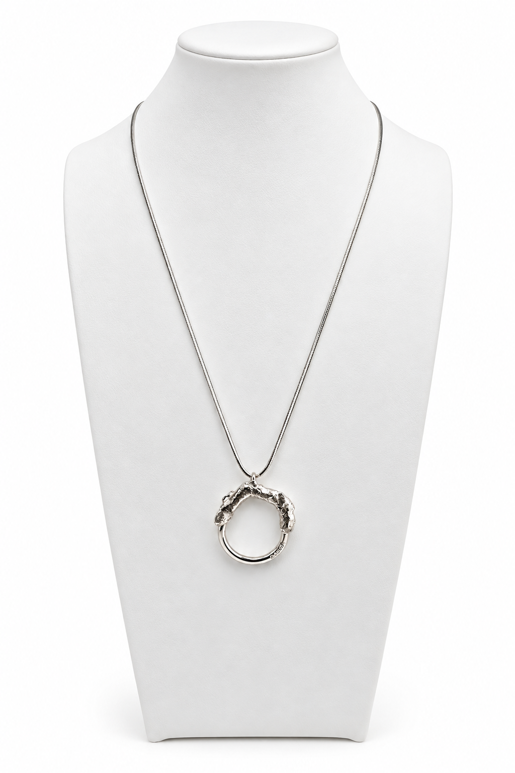 Melted and Modern sterling silver necklace displayed on a white jewelry bust, featuring a circular pendant with a textured molten silver upper form and smooth polished lower ring.