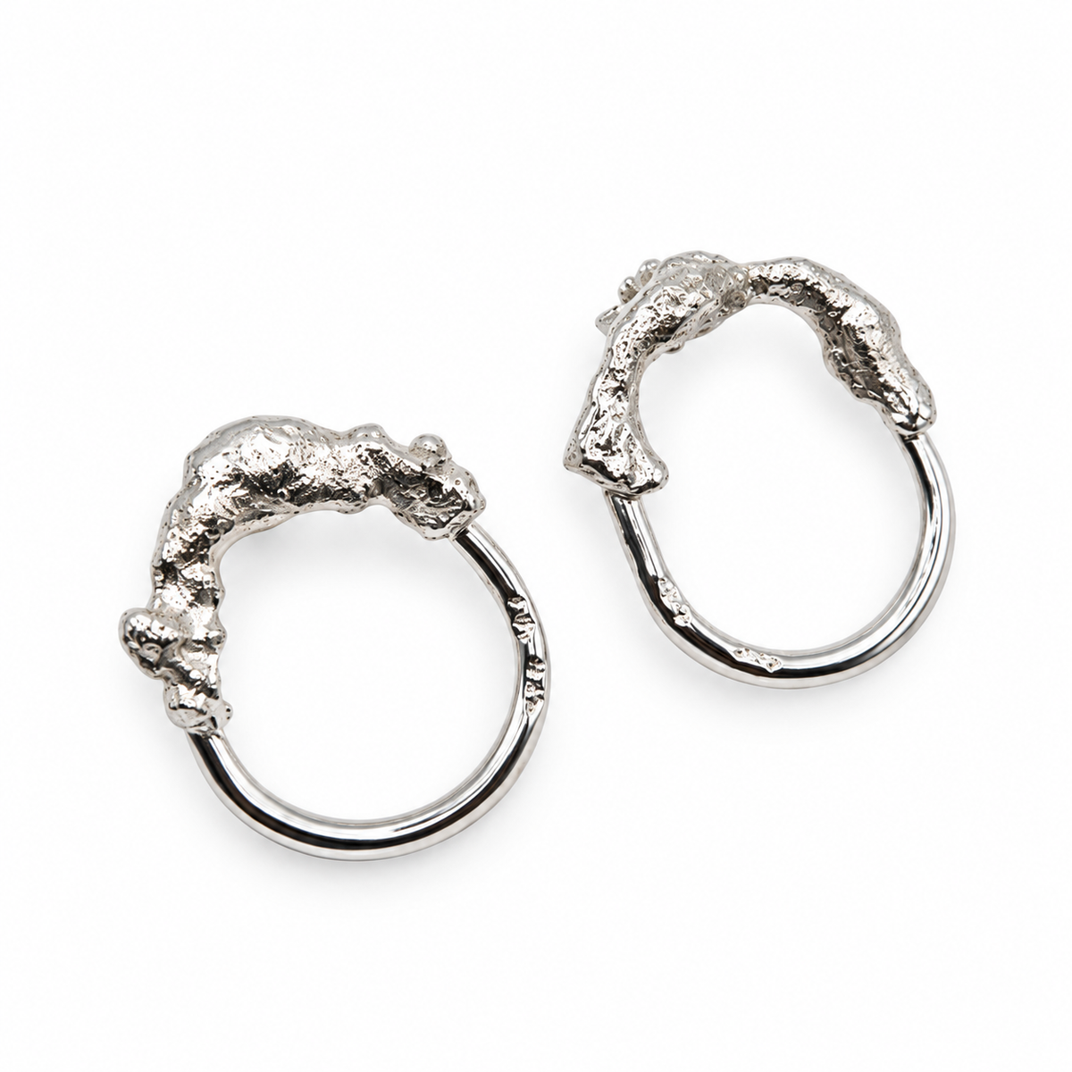 Close view of Melted and Modern sculptural sterling silver earrings showing the contrast between textured molten forms and smooth circular hoops, from Jill Melyssa’s Two Truths collection.