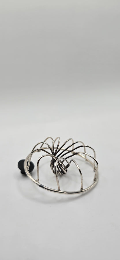 Non tarnish sterling silver votex wire shaped brooch  on a light gray background