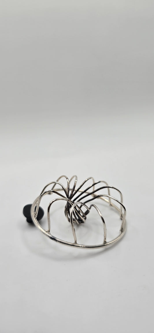 Non tarnish sterling silver votex wire shaped brooch  on a light gray background